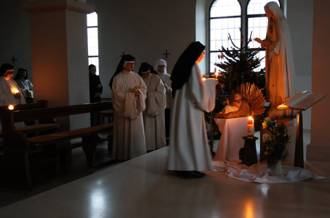 Wir entz&uuml;nden unsere Kerzen am Licht Christi an der Krippe